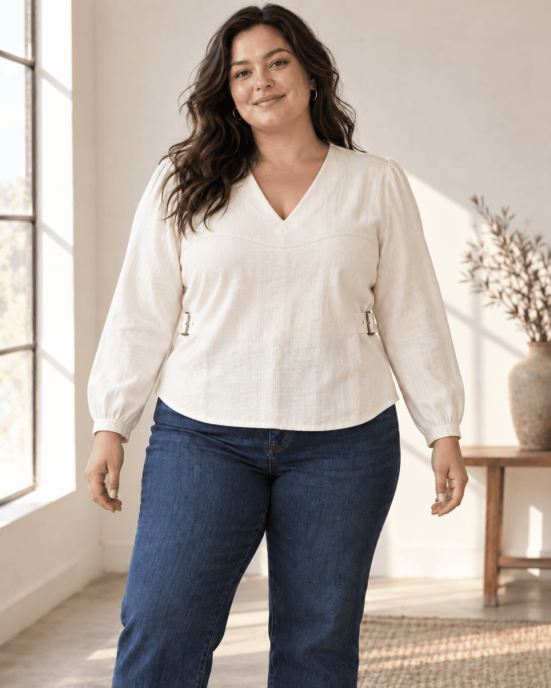 Plus-size model wearing the untucked ivory Shirae with dark denim